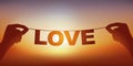 Concept of love with hands holding a banner on which is written the word love. Royalty Free Stock Photo