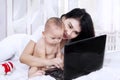 Mother and adorable baby playing with laptop Royalty Free Stock Photo