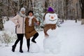 Mother and adult daughter sculpt a big real snowman Royalty Free Stock Photo