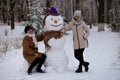 Mother and adult daughter sculpt a big real snowman Royalty Free Stock Photo