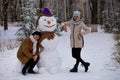 Mother and adult daughter sculpt a big real snowman Royalty Free Stock Photo