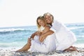 Mother And Adult Daughter Sitting Together On Beach Royalty Free Stock Photo