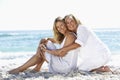 Mother And Adult Daughter Sitting Together On Beach Royalty Free Stock Photo