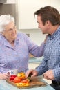 Mother and adult son preparing meal together