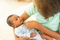 Mother African American holding one-month-old newborn baby gently. Royalty Free Stock Photo