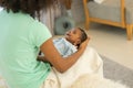 Mother African American holding one-month-old newborn baby gently. Royalty Free Stock Photo