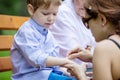 Mother applying band aid on scratch on son& x27;s arm outdoors Royalty Free Stock Photo