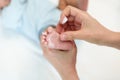 mother applying moisturizing cream on foot of newborn baby Royalty Free Stock Photo