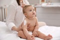 Mother applying moisturizing cream on her baby at home, closeup Royalty Free Stock Photo