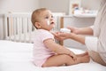 Mother applying moisturizing cream on her baby at home, closeup Royalty Free Stock Photo