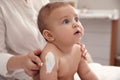 Mother applying moisturizing cream on her little baby at home, closeup Royalty Free Stock Photo