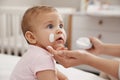 Mother applying moisturizing cream on her little baby at home, closeup Royalty Free Stock Photo