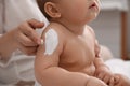 Mother applying moisturizing cream on her little baby at home, closeup Royalty Free Stock Photo