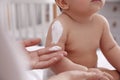 Mother applying moisturizing cream on her little baby at home, closeup Royalty Free Stock Photo