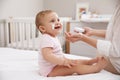 Mother applying moisturizing cream on her little baby at home, closeup Royalty Free Stock Photo