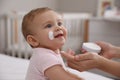 Mother applying moisturizing cream on her little baby at home, closeup Royalty Free Stock Photo