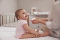 Mother applying moisturizing cream on her little baby at home, closeup Royalty Free Stock Photo
