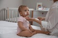 Mother applying moisturizing cream on her little baby at home, closeup Royalty Free Stock Photo