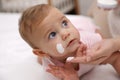 Mother applying moisturizing cream on her little baby at home, closeup Royalty Free Stock Photo