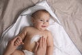 Mother applying moisturizing cream onto her little baby`s skin on bed, closeup Royalty Free Stock Photo