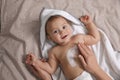 Mother applying moisturizing cream onto her little baby`s skin on bed, closeup Royalty Free Stock Photo