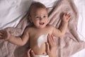 Mother applying moisturizing cream onto her little baby`s skin on towel, closeup Royalty Free Stock Photo