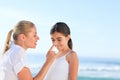 Mother applying sun cream on her daugter's nose Royalty Free Stock Photo