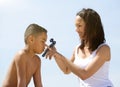 Mother applying sun cream on little boy