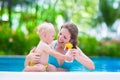 Mother applying sun screen on baby in swimming pool Royalty Free Stock Photo