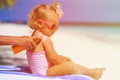 Mother applying sunblock cream on daughter shoulder