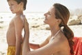 Mother Applying Sunscreen Cream On Son's Back
