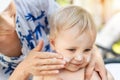 Mother applying sunscreen protection creme on cute little toddler boy face. Mom using sunblocking lotion to protect baby Royalty Free Stock Photo