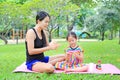 Mother appying body lotion for daughter`s in the summer park Royalty Free Stock Photo