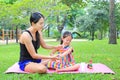 Mother appying body lotion for daughter`s in the summer park Royalty Free Stock Photo