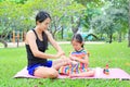 Mother appying body lotion for daughter`s in the summer park Royalty Free Stock Photo