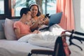 Mother and asian disabled child on the bed using notebook and smartphone