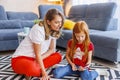 Mother assisting daughter with online lessons using tablet computer