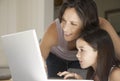 Mother Assisting Daughter In Using Laptop