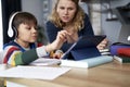 Mother assists her son while studying remotely Royalty Free Stock Photo