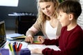 Mother assists her son while studying remotely Royalty Free Stock Photo