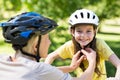 Mother attaching her daughters cycling helmet