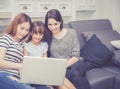 Mother, Aunt and kid having time together lerning with using laptop computer at home