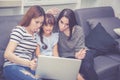 Mother, Aunt and kid having time together lerning with using laptop computer at home with relax and happy