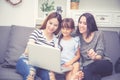 Mother, Aunt and kid having time together lerning with using laptop computer at home with relax and happy