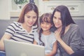 Mother, Aunt and kid having time together lerning with using laptop computer at home with relax and happy