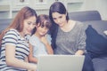 Mother, Aunt and kid having time together lerning with using laptop computer at home with relax and happy