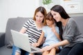 Mother, Aunt and kid having time together lerning with using laptop at home on couch