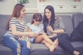 Mother, Aunt and kid having time together lerning with using tablet at home with relax and happy on couch