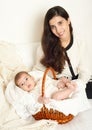 Mother with baby in basket on bed, happy family portrait on white background, yellow toned Royalty Free Stock Photo