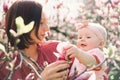 Mother and baby with blooming pink magnolia flower Royalty Free Stock Photo